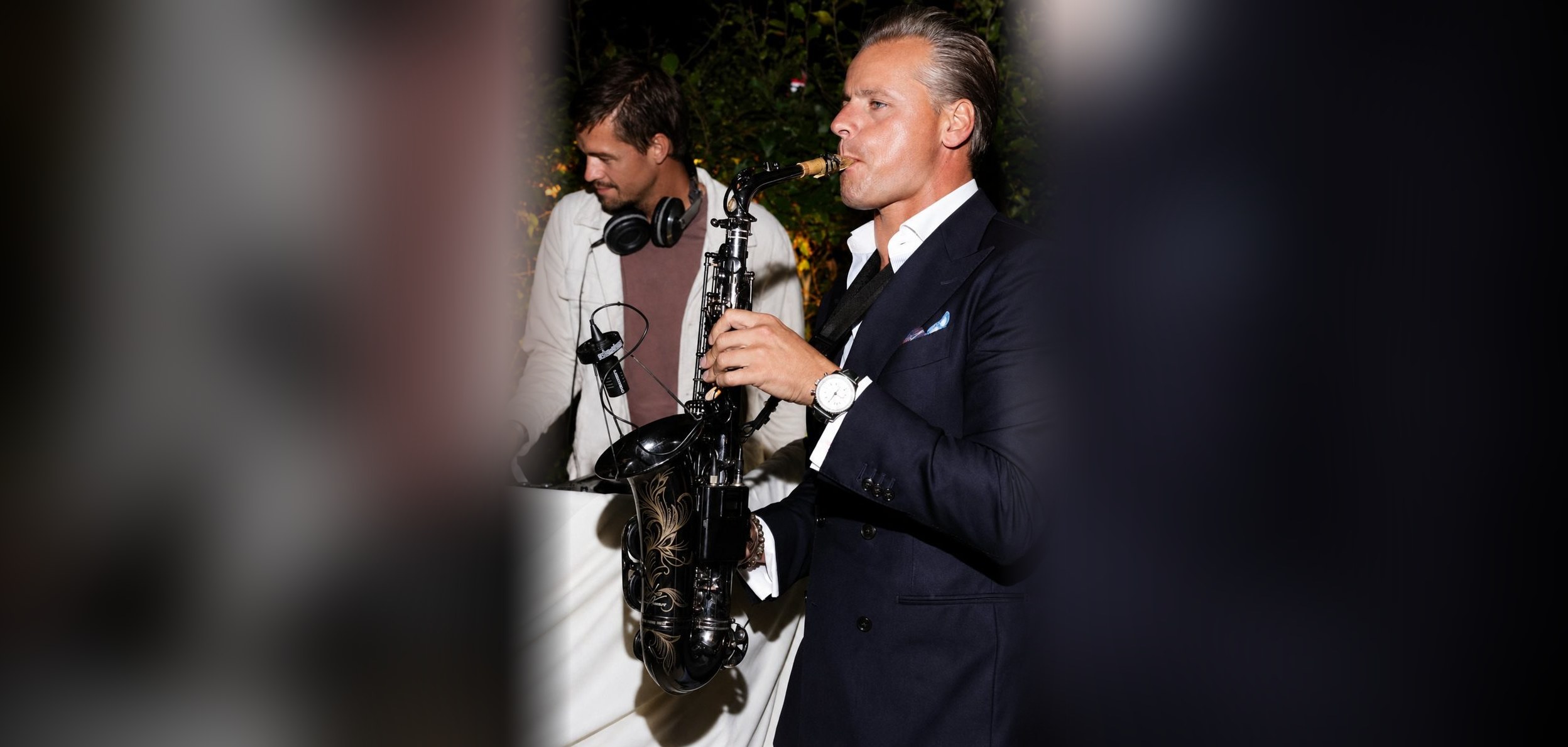 Dj en saxofonist tijdens een tuinfeest