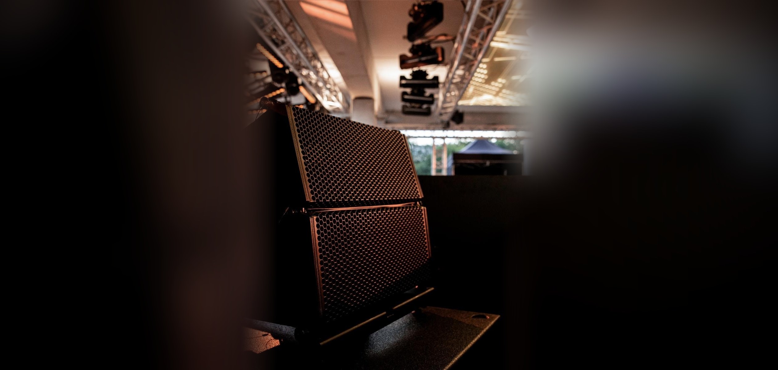 Luidsprekers onder een truss met moving heads
